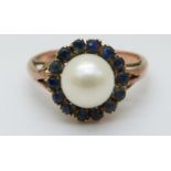 A 9ct gold ring set with a pearl surrounded by sapphires (size K)