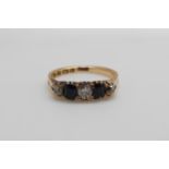 An 18ct gold ring set with three diamonds and two sapphires (size M)