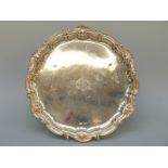 A hallmarked silver salver with shell rim raised on three ball and claw feet, Sheffield 1899,