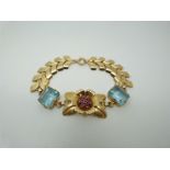 A Tiffany & Co 14k gold bracelet set with a cluster of rubies in a floral and foliate setting