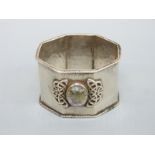 A Sybil Dunlop hallmarked silver Arts and Crafts hammered silver octagonal napkin ring with applied