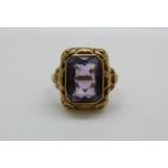 A yellow metal ring marked 333 set with an emerald cut amethyst, 3.