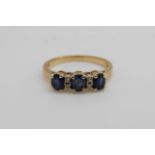 An 18ct gold ring set with three sapphires and diamonds (size M)