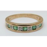 A 9ct gold ring set with alternating emeralds and diamonds (size P)