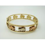 A tri-coloured 9ct gold bangle decorated with elephants, 22.