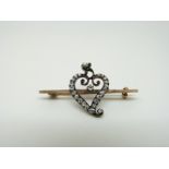 A late Victorian/ Edwardian brooch set with old mine cut diamonds in the form of a heart,