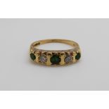 An 18ct gold ring set with emeralds and diamonds (size K)