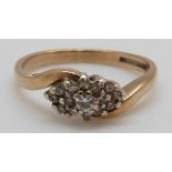 A 9ct gold ring set with diamonds in a cluster with a cross over design (size J)