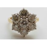 An 18ct gold ring set with seven round brilliant cut diamonds in a cluster,