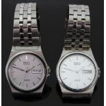 Two Seiko SQ100 stainless steel gentleman's wristwatches both with day and date apertures and two