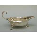 A George V hallmarked silver sauce boat raised on three feet, London 1921 maker Reid & Sons Ltd,