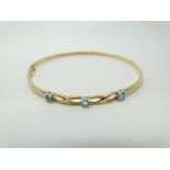 A 9ct gold bangle set with blue topaz, 4.