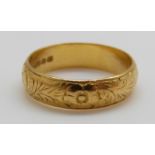 A 22ct gold wedding band with chased decoration, 6.