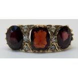 An 18ct gold ring set with large garnets and diamonds (size R )