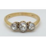 An 18ct gold ring set with three old cut diamonds in a platinum setting,