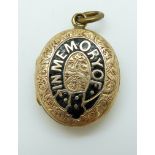 A Victorian locket reading 'In memory of' in black enamel with chased foliate design