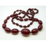 A cherry amber necklace of 57 graduated ovoid beads, the largest approximately 28x22mm, 61g,