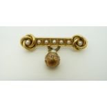 A Victorian brooch in the form of two knots each set with a pearl and a row of pearls between them,