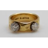An 18ct gold ring set with two diamonds each measuring approximately 0.
