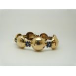 A Tiffany & Co bracelet set with diamonds and sapphires in flower clusters between gold spheres
