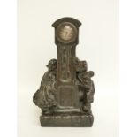 A late 19thC bronze clock/model in the form of a longcased clock and two figures of Dutch children,