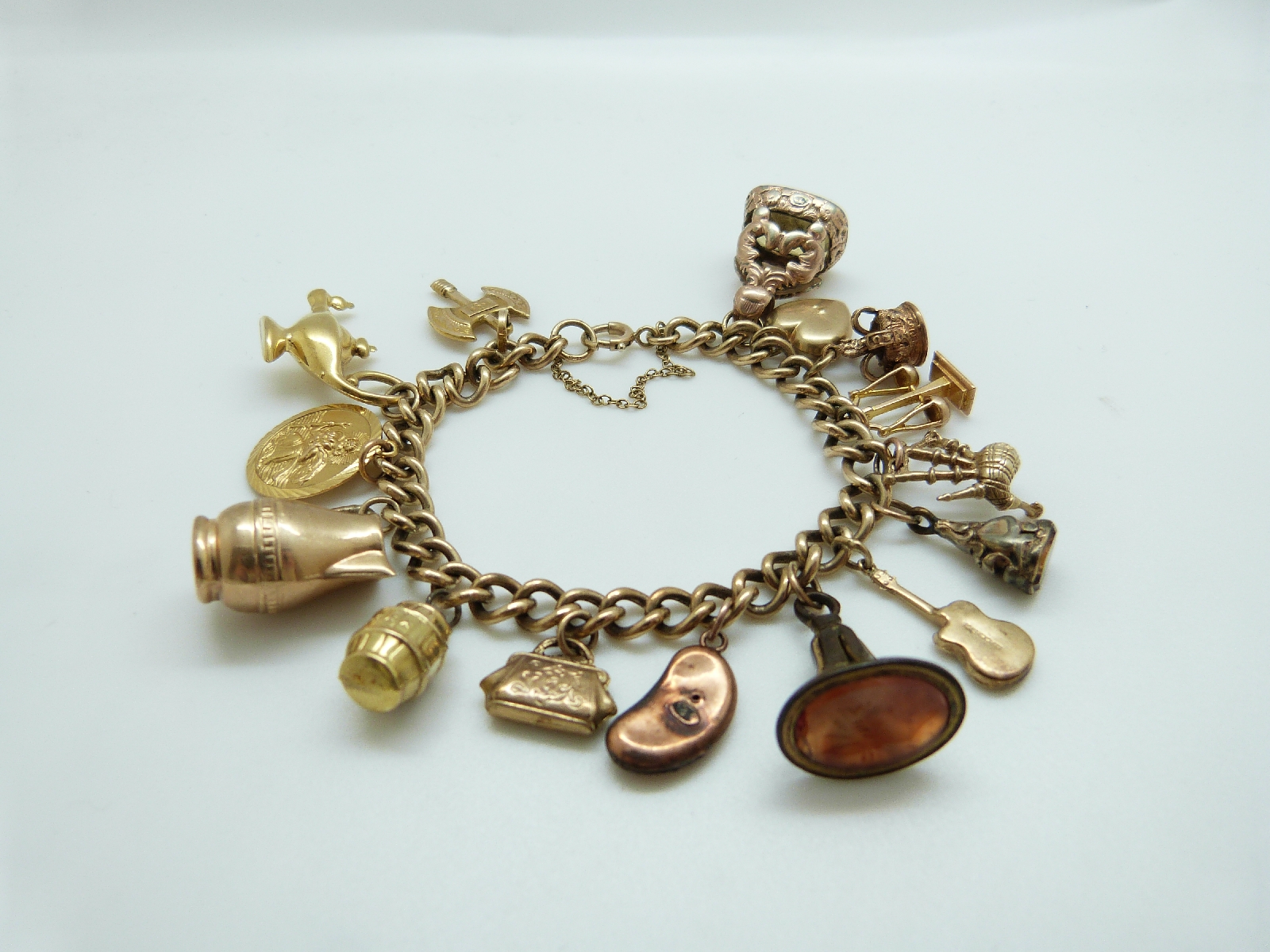 A 9ct gold charm bracelet with eleven 9ct gold charms including a crown, St Christopher, purse, - Image 2 of 8