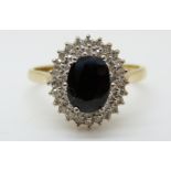 An 18ct gold ring set with a sapphire surrounded by two rows of diamonds (size N)