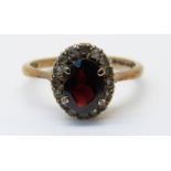 A 9ct gold ring set with a garnet and paste (size M)