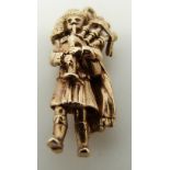 A 9ct gold charm in the form of a bagpipe player, 5.