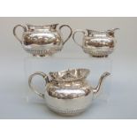 A Victorian hallmarked silver three piece tea set with engraved decoration, London 1878,