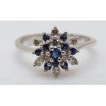 A 9ct white gold ring set with sapphires and diamonds in a cluster