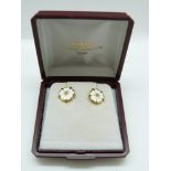 A pair of 9ct gold earrings set with white and green enamel in the form of flowers, 3.
