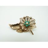 A 9ct gold brooch set with pearls and turquoise in a floral and foliate design