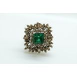 An 18ct white gold ring set with a square cut emerald of approximately 1ct surrounded by baguette