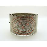 A Victorian silver cuff/ bangle with applied gold foliate and floral decoration