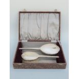 A cased hallmarked silver three piece dressing table set comprising mirror, brush and comb,