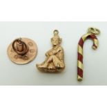 A 9ct gold charm in the form of a candy stick set with red enamel,