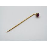 A Victorian stick pin set with a ruby cabochon, 5.7cm (ruby cabochon 5.
