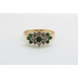 An 18ct gold ring set with emeralds and diamonds in a cluster (size K/L)