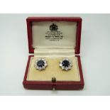A pair of platinum earrings set with a round cut sapphire measuring approximately 1.