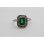 An Art Deco platinum ring set with an emerald cut emerald of approximately 0.
