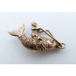 A 9ct pendant/ charm in the form of a cherub riding a fish, 3.