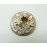 A hallmarked silver Scottish brooch in the form of a thistle set with an orange stone,