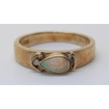 A 9ct gold ring set with a pear cut opal and diamonds (size M)