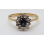 An 18ct gold ring set with an oval sapphire surrounded by diamonds (size P)