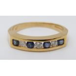 An 18ct gold ring set with alternating sapphires and diamonds (size M)
