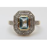 A 9ct gold ring set with a topaz surrounded by diamonds in a rectangular setting (size M)