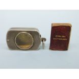 A Victorian silver novelty miniature book holder with magnifier to the swivel lid containing a