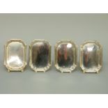 A set of four George V hallmarked silver pin dishes with shaped corners,