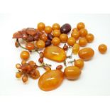 Twenty-one egg yolk coloured amber beads, the largest approximately 20x15mm,